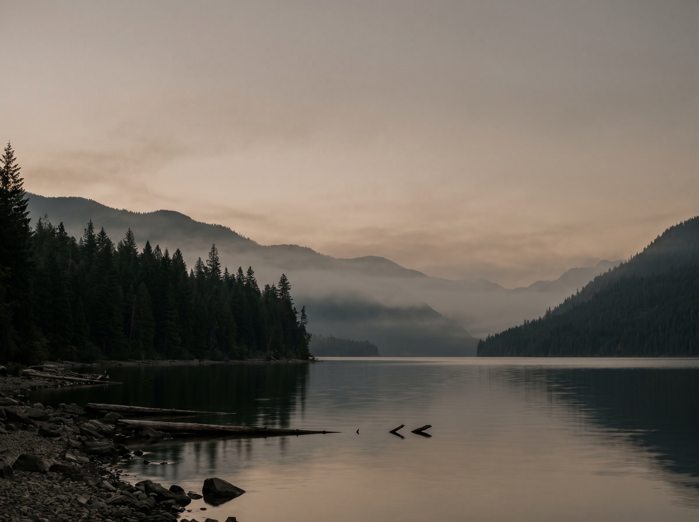 A lake and forested ridgeline at dawn.